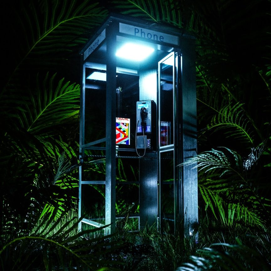 Prenota Ora Telefono bianco su uno sgabello, con sfondo viola.