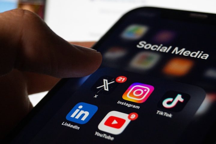 Social Media e Branding Hand tapping a smartphone screen displaying various social media app icons.