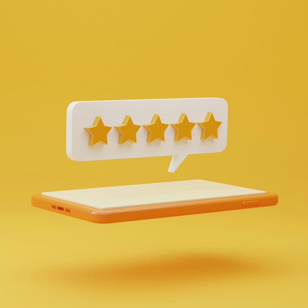 Icon of five yellow stars in a speech bubble above a tablet on a yellow background.